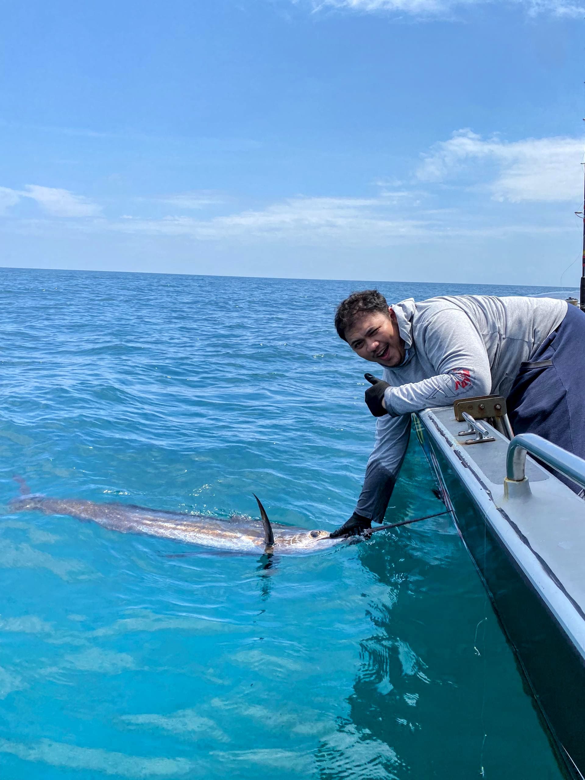 A thumbs-up for a successful catch and a healthy release in Kuala Rompin, where sustainable sportfishing keeps the ocean thriving