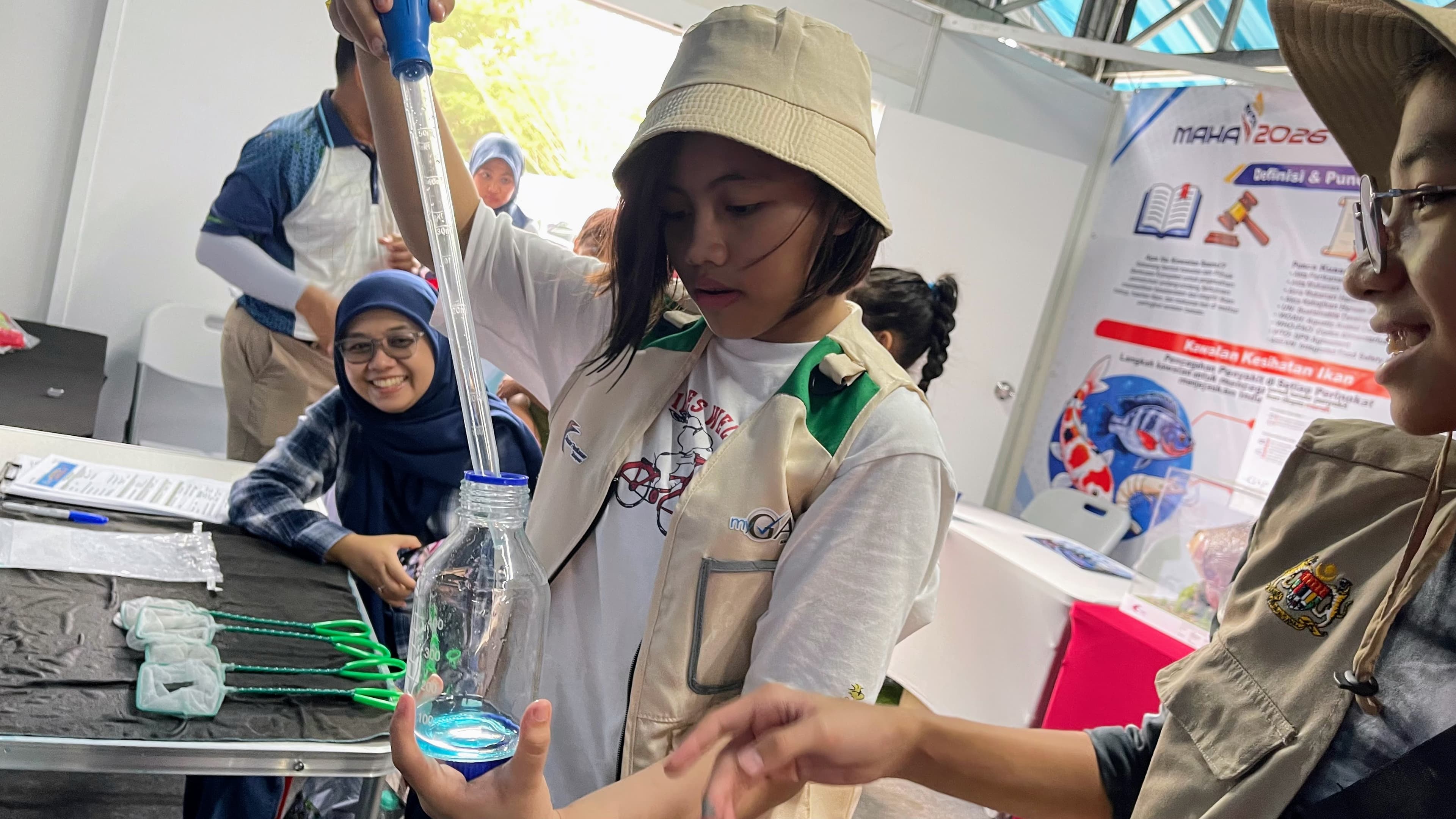 Experiential Learning on Biosecurity, Hana using a pipet to obtain water sample.